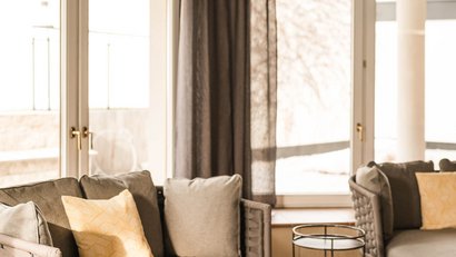 Cozy seating area with gray sofa, cushions and open book by window