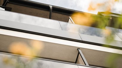 Blick nach oben auf moderne Balkonbrüstungen mit Glas und Metallgeländer