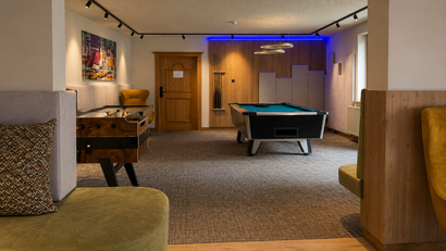 Spielzimmer mit Billardtisch, Tischfußball und bequemen Sitzgelegenheiten