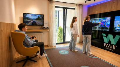 Jugendliche spielen Videospiele in einem modernen Spielzimmer mit Wandbildschirm