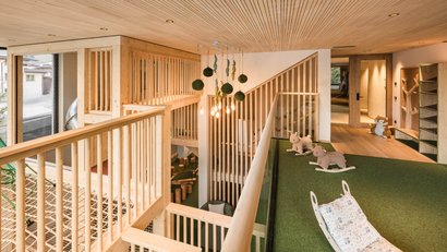 Kinderbereich mit Holzgeländer, Teppichboden und Spielzeugen im modernen Innenraum