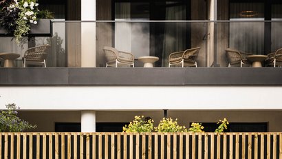 Moderner Balkon mit Gartenmöbeln und Pflanzen im Vordergrund