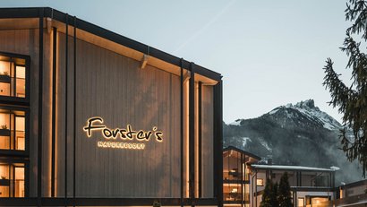 Forstner's Naturresort vor Berg und Bäumen in der Abenddämmerung