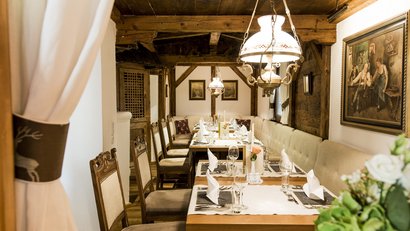 Gemütlicher Essbereich mit Holzdecke und gedecktem Tisch für Gäste