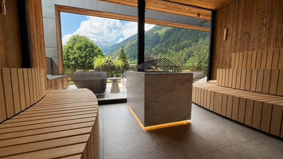 Moderner Saunaraum mit Holzvertäfelung und Bergblick durch große Fenster