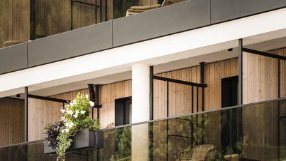 Moderner Balkon mit Holzverkleidung und Blumenkasten