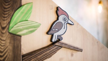 Holzklammer in Vogel- und Blattform an einer holzfarbenen Oberfläche