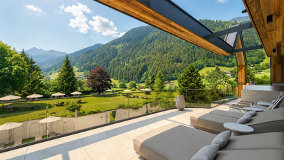 Terrasse mit Liegestühlen und Bergblick bei sonnigem Wetter