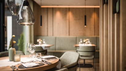 Modernes Restaurant mit elegant gedeckten Tischen und warmem Holzdekor