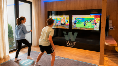 Zwei Kinder spielen interaktives Videospiel an iWall in modernem Raum