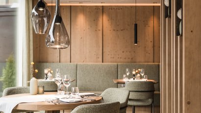 Cozy restaurant with wood decor and green upholstered chairs