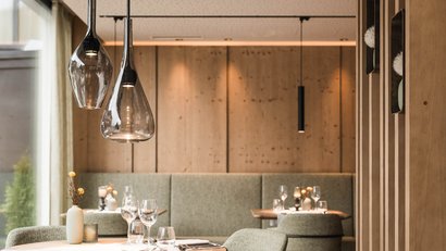 Gemütliches Restaurant mit Holzdekor und grünen Polstersesseln