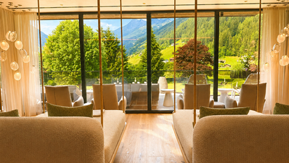 Gemütlicher Innenraum mit Schaukeln und Bergblick durch große Fenster