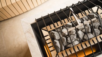 Saunaofen mit heißen Steinen und Schutzgitter