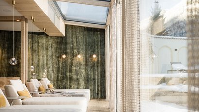 Helle gemütliche Lounge mit Sitzgelegenheiten und Blick auf verschneite Terrasse