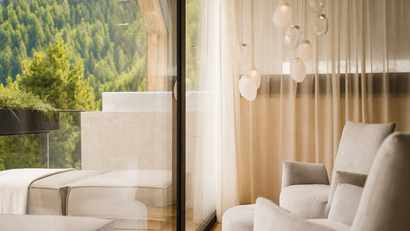 Gemütlicher Sitzbereich mit Blick auf bewaldeten Balkon und moderne Hängelampen