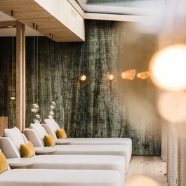 Moderne Relaxliegen mit Kissen in einem hellen Raum mit Glasdach