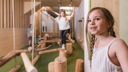Mädchen spielen auf einem Holzspielplatz im Innenbereich