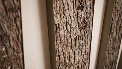 Nahaufnahme von vertikalen Holzpaneelen mit rauer Rinde