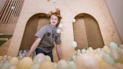 Kinder spielen in einem Holz-Spielplatz mit Netz und Bällen