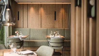 Gemütlicher Restaurantbereich mit Holzwänden und gedeckten Tischen
