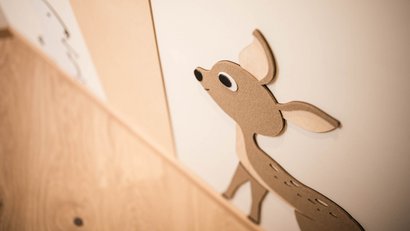 Holzdekor eines Rehs an weißer Wand