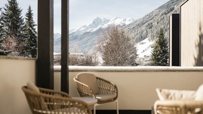 Balkon mit Stühlen und schneebedeckten Bergen im Hintergrund