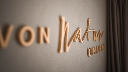Holzschriftzug von Natrm an grauer Wand