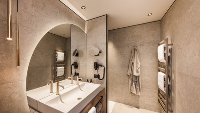 Modernes Badezimmer mit großem Spiegel, Doppelwaschbecken und Handtuchwärmer