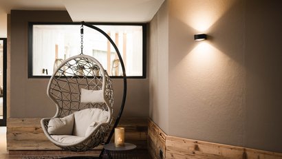 Moderner, bequemer Hängesessel in gemütlicher Ecke mit Kerzenlicht