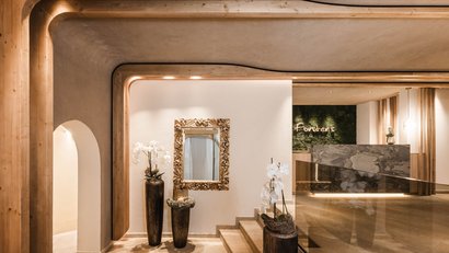 Eleganter Hotel-Eingangsbereich mit Spiegel, Orchideen und Holzverkleidung