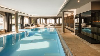 Heller Innenpool mit Sitzbereich und Sauna rechts