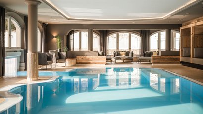 Hallenbad mit gemütlichen Sitzbereichen und großen Fenstern