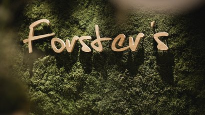 Holzschriftzug Forever's auf einer grünen Mooswand