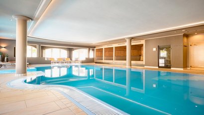 Innenbereich mit klarem Schwimmbad und Liegestühlen