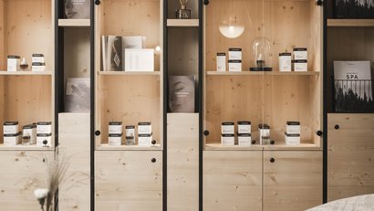 Helle Holzregale mit Kosmetikprodukten in modernem Wohnzimmer