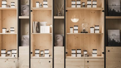 Helle Holzregale mit Kosmetikprodukten in modernem Wohnzimmer