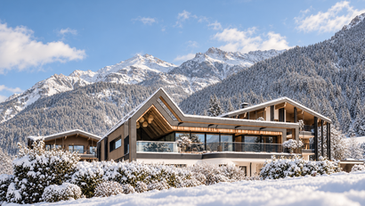 Moderne Chalets im verschneiten Bergtal unter blauem Himmel