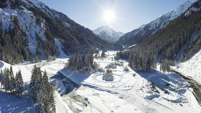 Winterlandschaft mit schneebedeckten Bergen und Sonnenschein