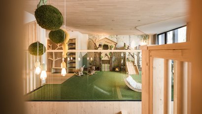 Moderner, kindgerechter Spielbereich mit Rutsche und Schaukeltierfiguren