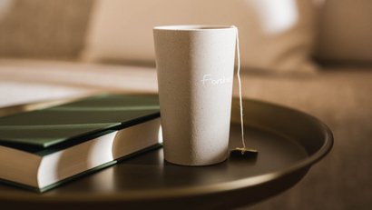 Teacup and book on a round table in front of a sofa