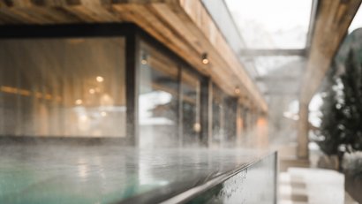 Dampfendes Schwimmbad im Freien an einem bewölkten Tag