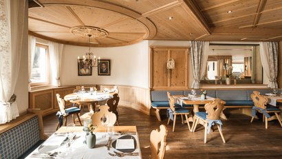 Gemütliches Restaurant mit Holzmöbeln und Tischgedecken im traditionellen Stil