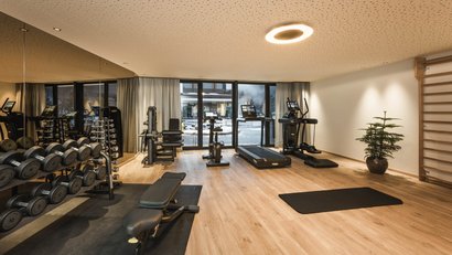 Moderner Fitnessraum mit Geräten, Hanteln und Panoramafenster
